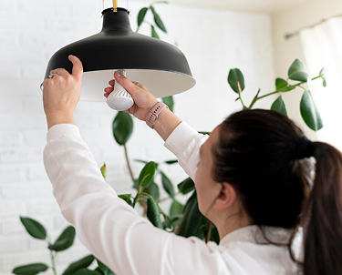 Person changing pendant light bulb.