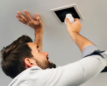 Person replacing recessed light.
