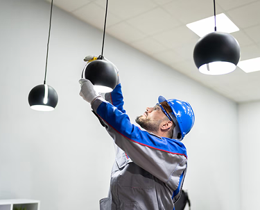 Electrician installing a black pendant light.