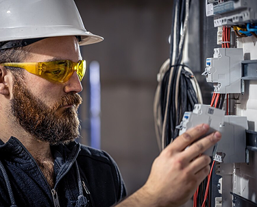 Electrician inspecting a circuit breaker panel.
